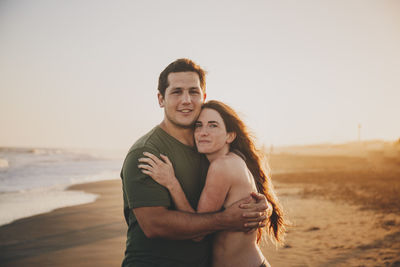 Portrait of young couple standing at beach