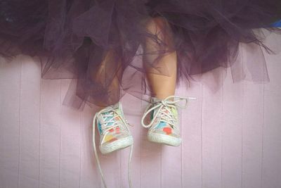 Low section of woman hanging against wall