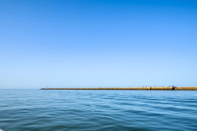 Scenic view of sea against clear blue sky