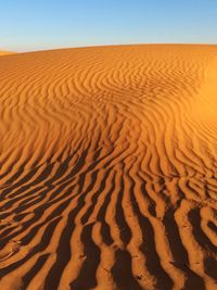 Sand dune in desert against clear sky