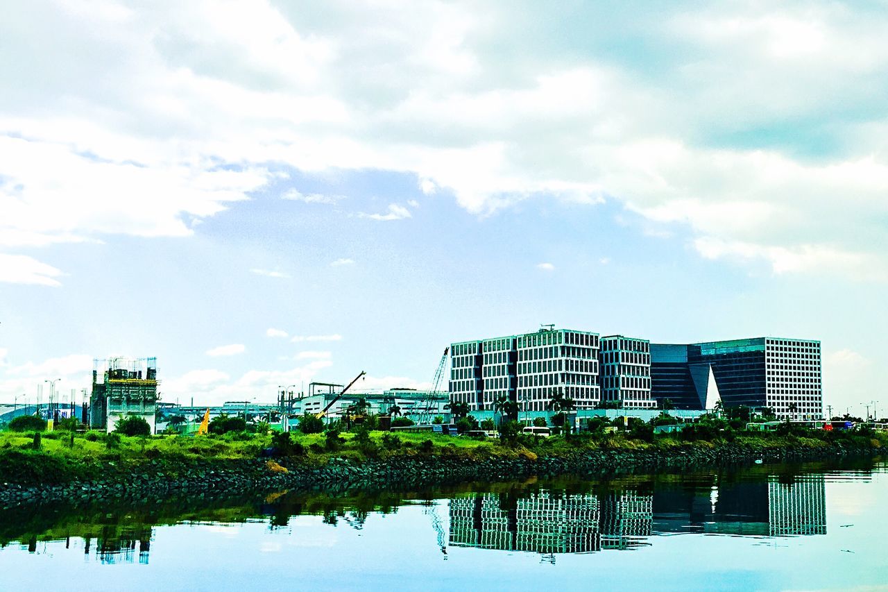 building exterior, architecture, built structure, sky, reflection, city, water, tree, cloud - sky, waterfront, building, cloud, tower, tall - high, growth, day, skyscraper, residential building, modern, office building