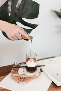 Midsection of woman holding ice cream on table