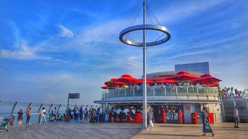 People on street against blue sky