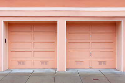 Two single car garage doors painted with pastel color.