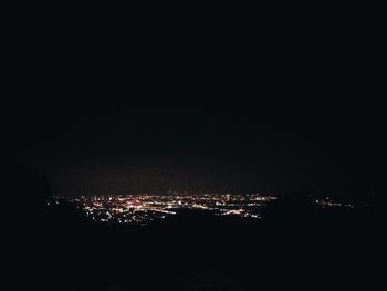 Illuminated city against sky at night