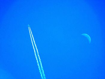 Low angle view of vapor trail against clear blue sky