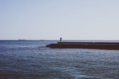 Man on sea against clear sky