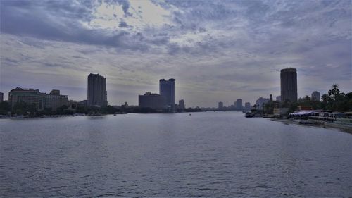 Panoramic view of sea and buildings against sky during sunset