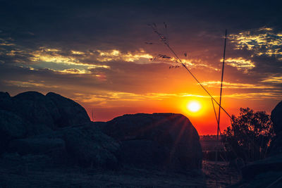 Scenic view of silhouette mountains against romantic sky at sunset