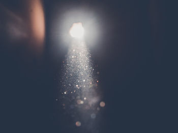 Close-up of illuminated lights against sky at night