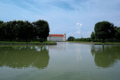 Scenic view of lake by trees against sky