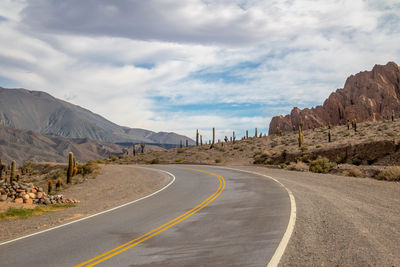 Road by mountain against sky