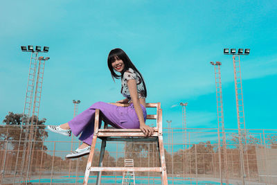 Portrait of woman sitting on tennis courts