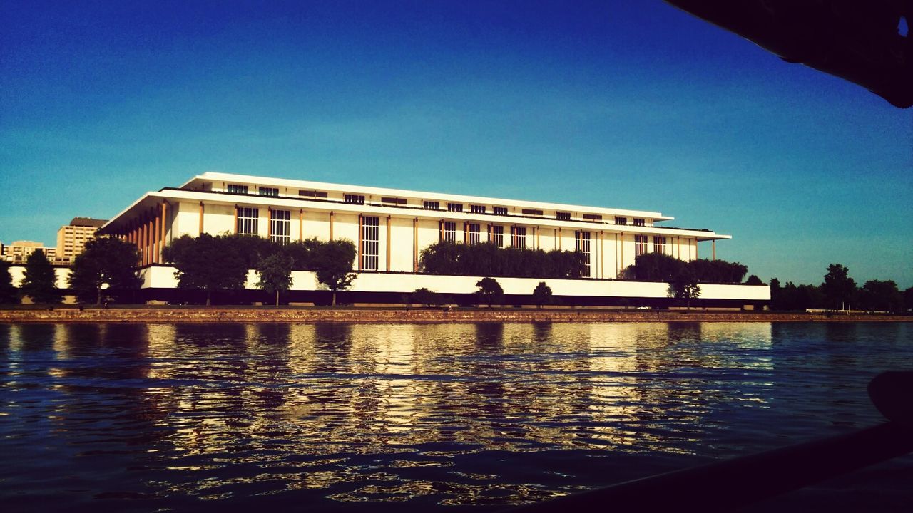 water, architecture, built structure, building exterior, reflection, clear sky, blue, waterfront, river, copy space, city, illuminated, sky, dusk, rippled, silhouette, outdoors, travel destinations, no people, canal