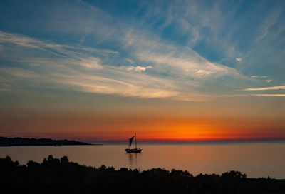 Scenic view of sea against dramatic sky during sunset