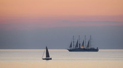 Sailboat on sea against sky during sunset