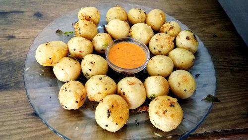 Suji appe or rice appe or appam, an indian snack with onion, peanuts and tamarind dip in india