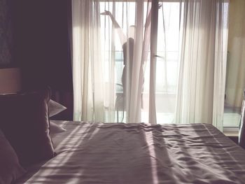 White curtain hanging on bed at home