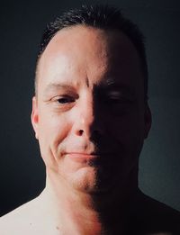 Close-up portrait of young man against black background