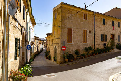 Empty road amidst buildings in city against sky