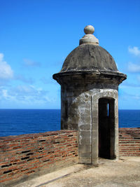 Built structure by sea against sky