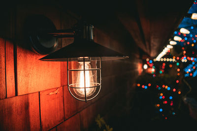 Illuminated light bulbs hanging on wall at home