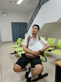 Portrait of young man sitting on chair
