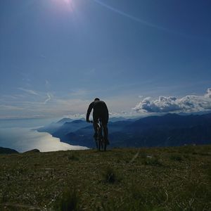 Rear view of man riding bicycle on mountain