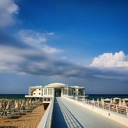 Bridge over sea against blue sky