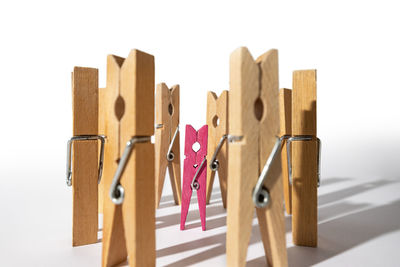 Close-up of clothespins on rope against white background
