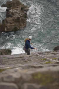 Man surfing on rock in sea