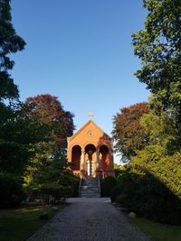 View of temple amidst trees and building against sky