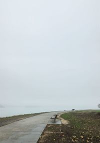 Road amidst field against sky