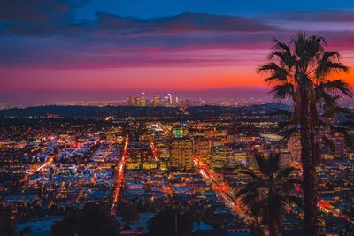 High angle view of city lit up at sunset