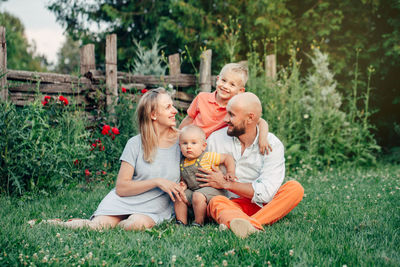 Happy family sitting on grass at park