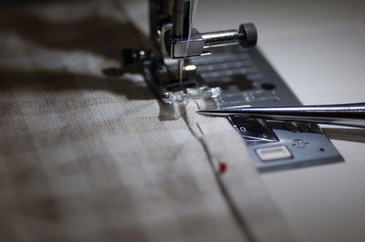 Close-up of fabric and sewing machine at home