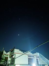 Low angle view of buildings against sky at night