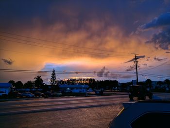 Silhouette cars on road against sky during sunset