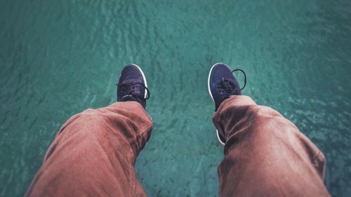 Low section of man standing in water