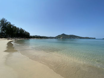 Scenic view of beach against clear blue sky