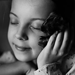 The girl narrowed her eyes in love with her pet guinea pig holding it