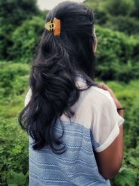 Rear view of woman standing on green field