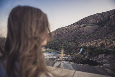 Rear view of woman in mountains against clear sky