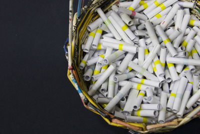 High angle view of rolled up papers in wicker basket on black background