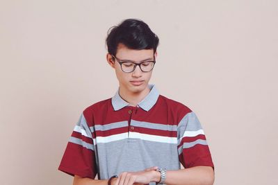 Portrait of young man standing against white background