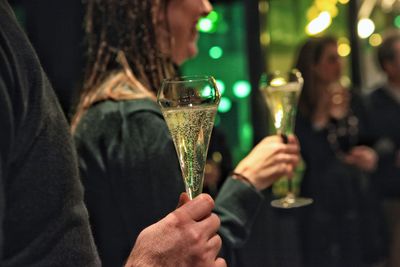 Midsection of people holding glass of pinot. 