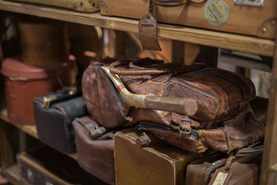 Old tennis racket inside a brown leather bag on a shelf.