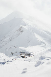 View of cable car station in front of snowy mountains