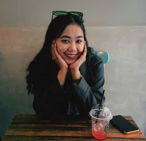 Portrait of young woman sitting on table