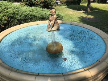 Reflection of person in water fountain in swimming pool